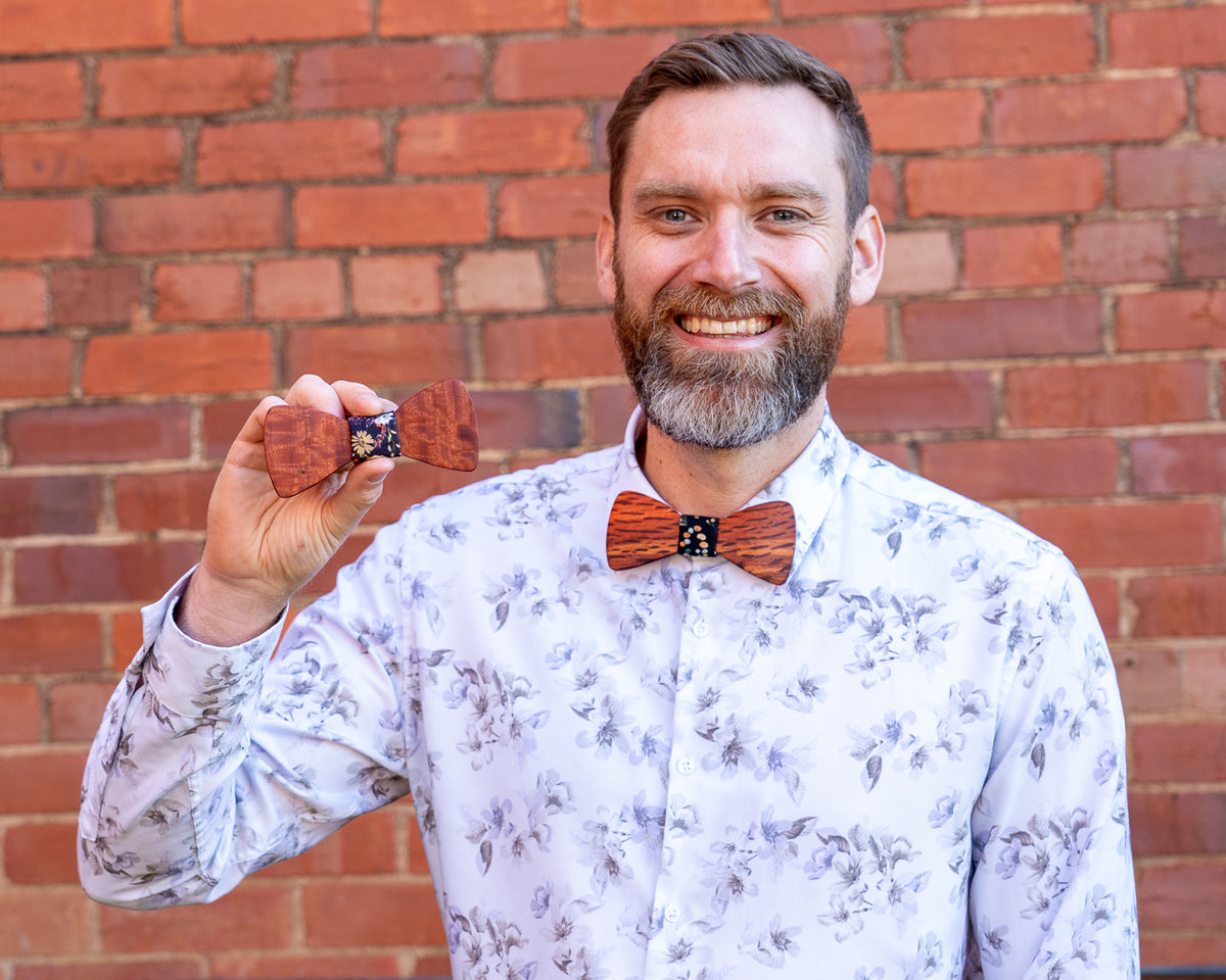 Ash wearing a magnetic wooden bowtie and holding another timber design