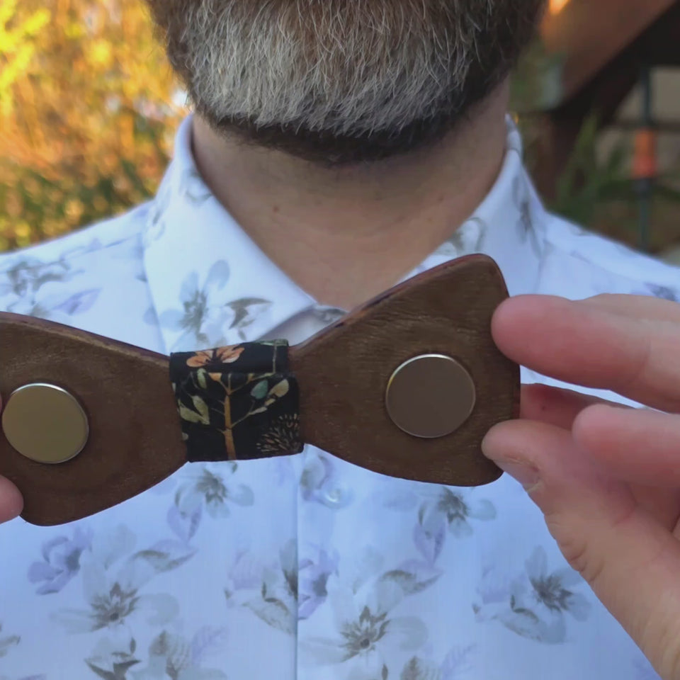 Ash demonstrating how to attach his magnetic wooden bowtie to a shirt collar